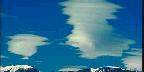 Clouds Between Trees And Mountain