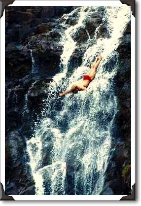 Cliff divers against waterfall